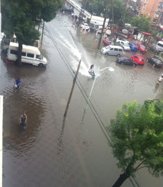 天津大雨过后 男子马路上开摩托艇(图)