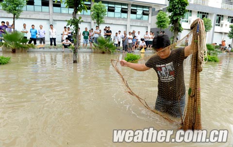 大暴雨席卷广西北海 市民积水路段拉网抓鱼