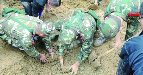 10月4日，武警官兵彝良山体滑坡现场找寻遇难者遗体